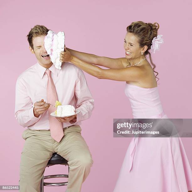 bridesmaid smashing cake onto face of guest - cake smashing stock pictures, royalty-free photos & images