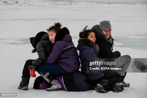 Young Inuit girls playing around and waiting for the arrival of the dogs sleds. Since 2001, Ivakkak has been an event which honors the Husky dogs,...