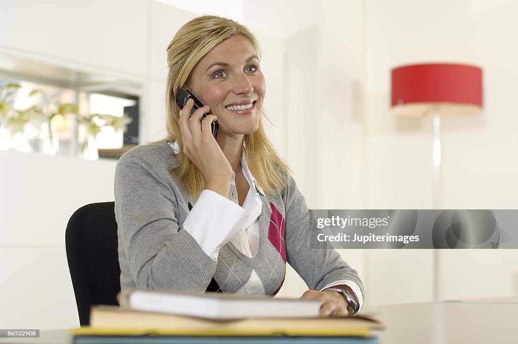 Woman on cell phone sitting in office