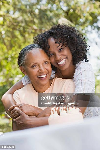 mother and daughter with birthday cake - older woman birthday stock pictures, royalty-free photos & images