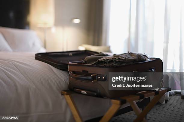 open suitcase on bed - luggage rack stock pictures, royalty-free photos & images