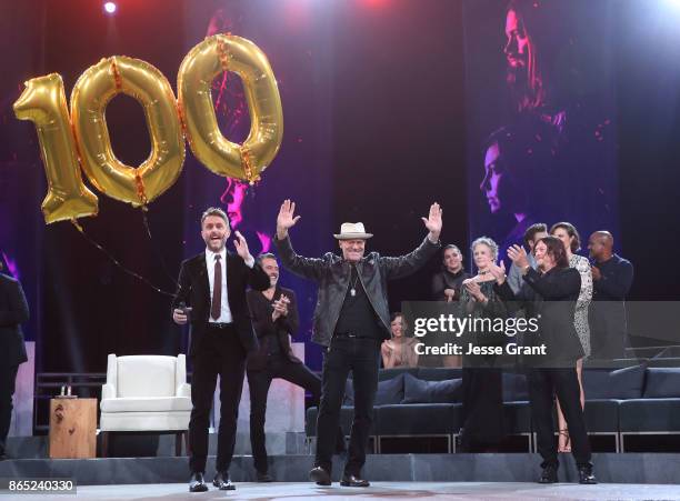 Michael Rooker gestures to the audience as host Chris Hardwick looks on onstage at The Walking Dead 100th Episode Premiere and Party on October 22,...