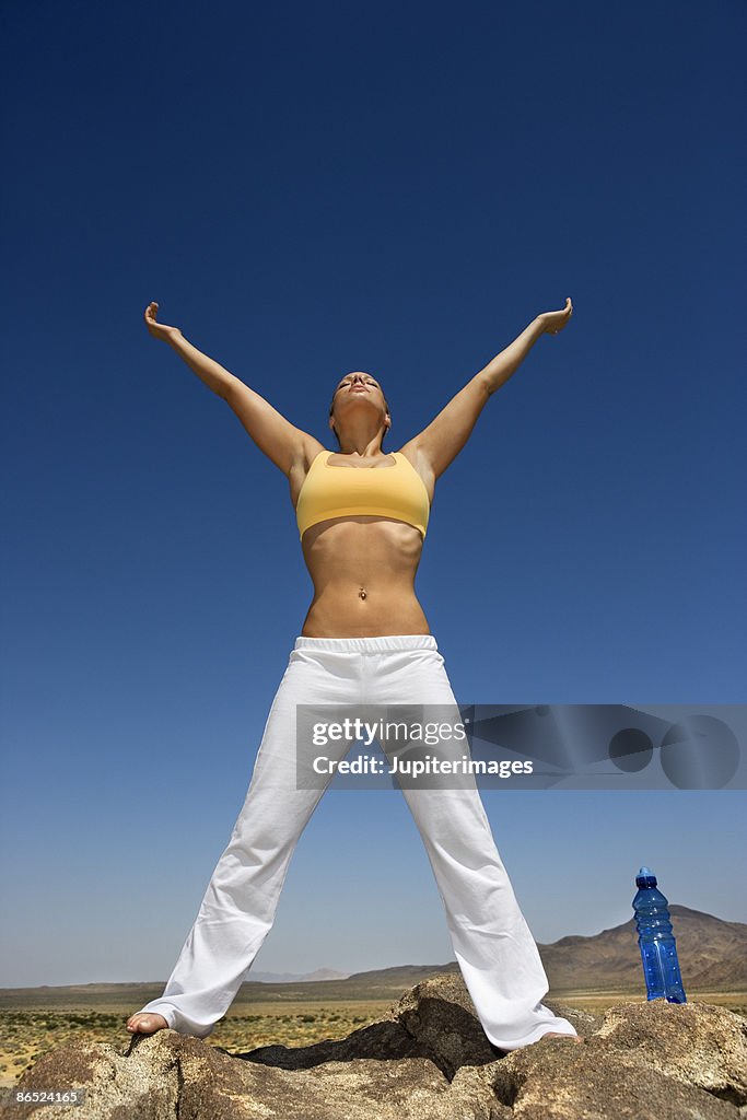 Woman with arms outstretched in desert