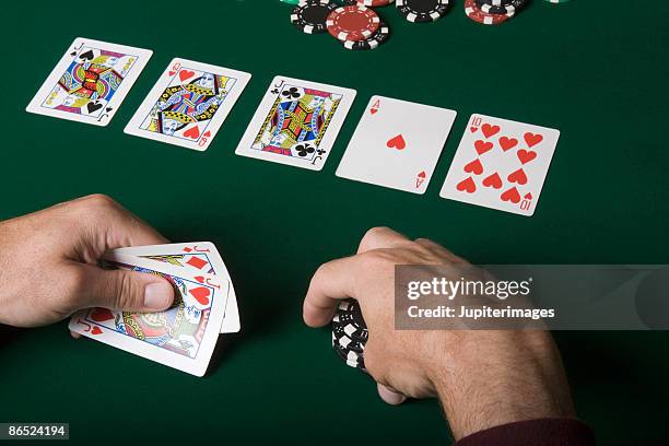 man holding playing cards and poker chips - texas hold 'em stock pictures, royalty-free photos & images