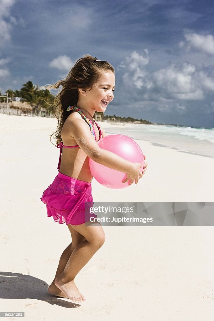 Girl playing with ball at the beach