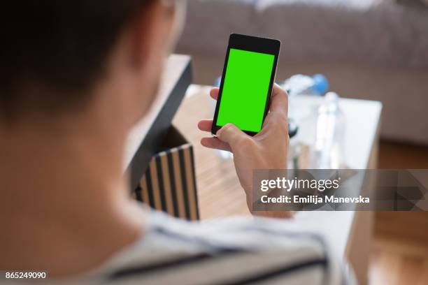 green screen handheld smartphone - chroma key stock pictures, royalty-free photos & images