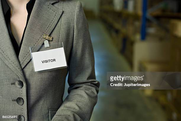 businesswoman with visitor badge - torse photos et images de collection