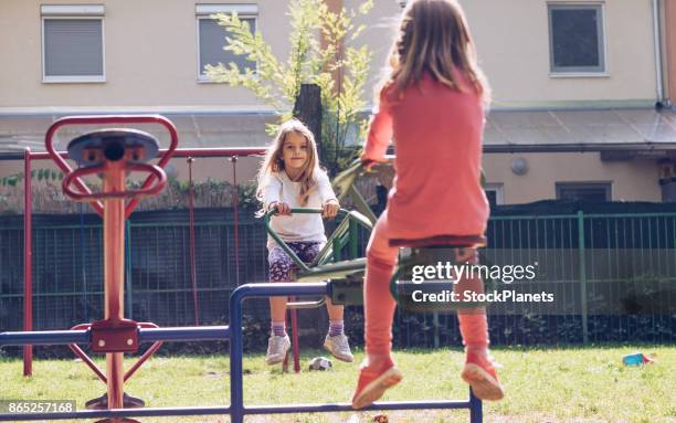 dos chicas lindas en balancín - see saw fotografías e imágenes de stock