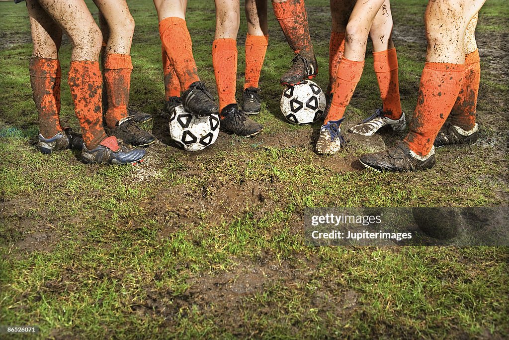 Muddy legs of soccer players
