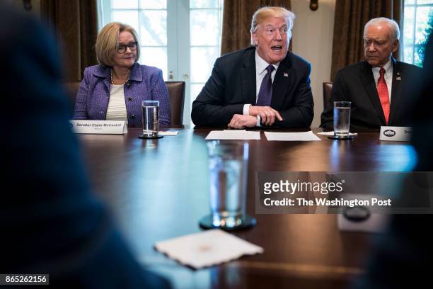 President Donald Trump, flanked by Sen. Claire McCaskill, D-Mo., left, and Sen. Orrin Hatch, R-Utah, right, speaks during a meeting with members of...
