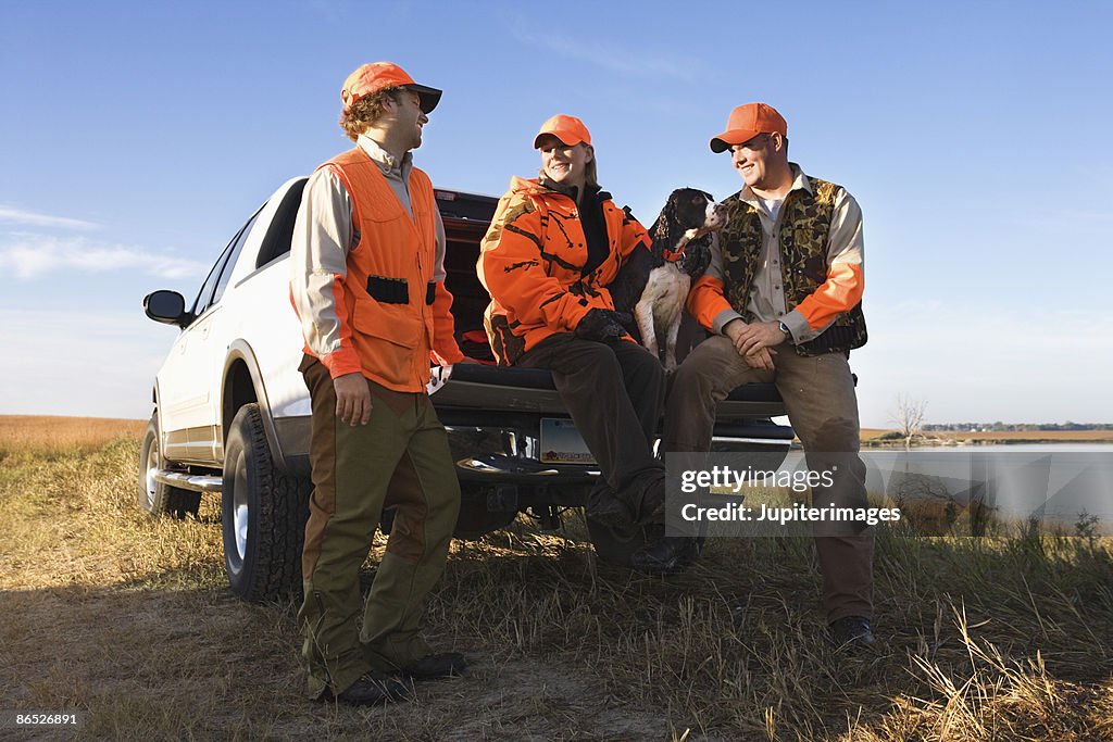 Hunters sitting on tailgate of truck