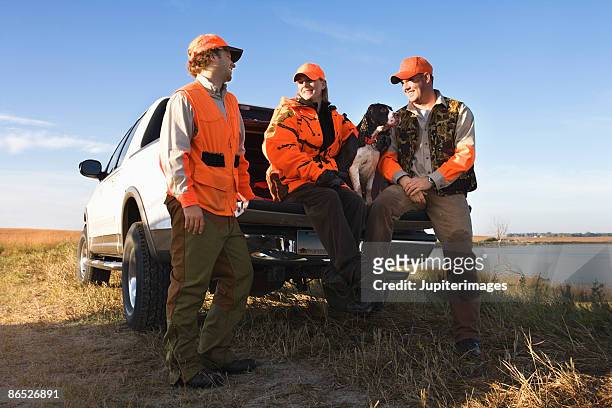 hunters sitting on tailgate of truck - pic hunter imagens e fotografias de stock
