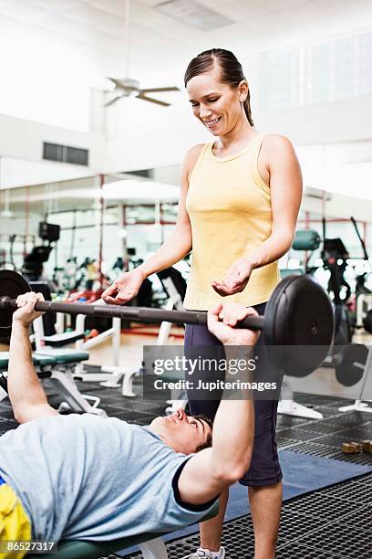 woman spotting man lifting barbell - spotting bildbanksfoton och bilder