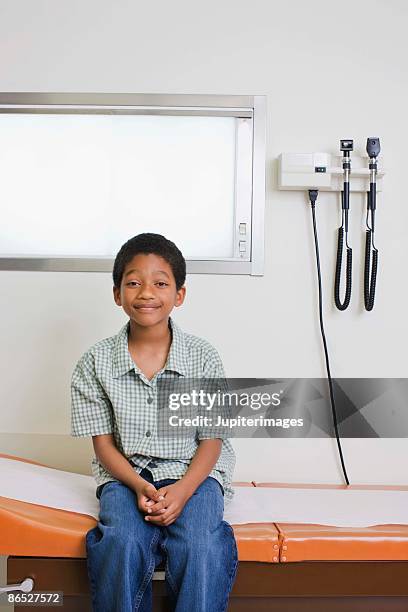 boy sitting on examining table - examination table stock pictures, royalty-free photos & images
