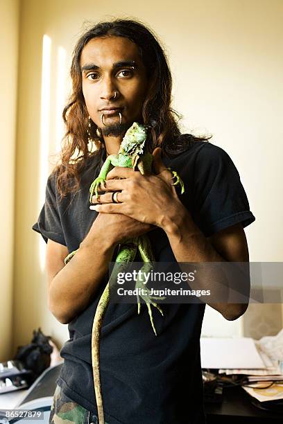 man with pet iguana - iguana stock pictures, royalty-free photos & images