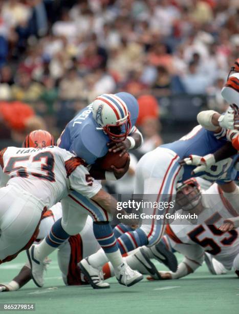 Running back Earl Campbell of the Houston Oilers runs with the football against linebacker Bo Harris of the Cincinnati Bengals during a game at...