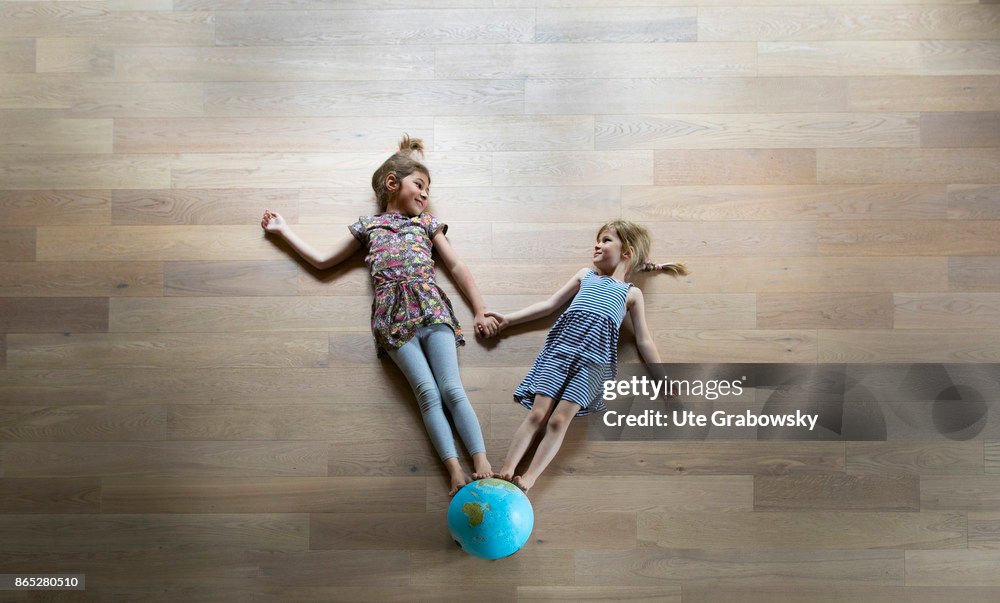 Children standing on a globe