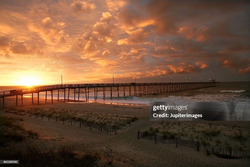 Pier on beach at sunrise, Oak Island, North Carolina