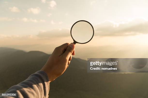 hand hold magnifying glass - vinden stockfoto's en -beelden