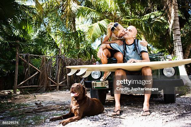 couple sitting on car with surfboard and dog - sitting in car stock pictures, royalty-free photos & images