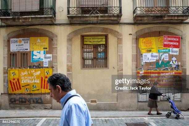 People walk past Catalan pro-independence graffiti on October 23, 2017 in Barcelona, Spain. The Spanish government is to take steps to suspend...