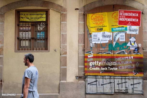 Man walks past Catalan pro-independence graffiti on a doorway on October 23, 2017 in Barcelona, Spain. The Spanish government is to take steps to...