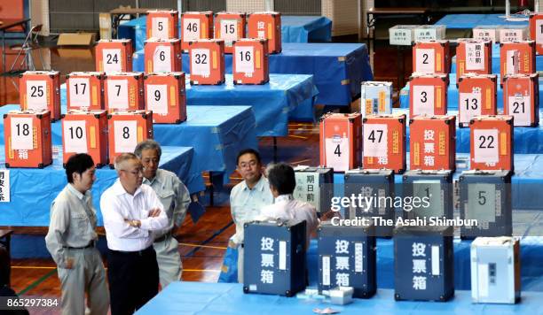 Staffs wait for the start of vote counting a day after the general election as it was delayed by Typhoon Lan on October 23, 2017 in Nobeoka,...