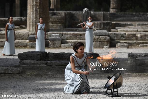 Actress Katerina Lechou acting the high priestess passes the Olympic flame at the Temple of Hera on October 23, 2017 during a dressed rehearsal of...