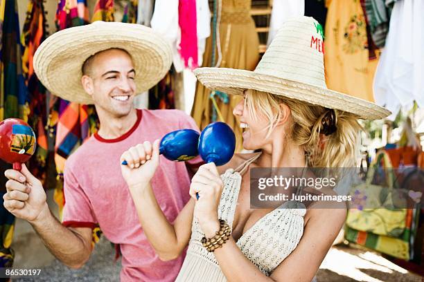 couple shaking maracas in store - maracas stockfoto's en -beelden