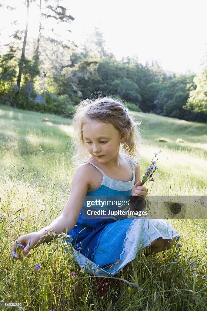Girl picking wildflowers in meadow