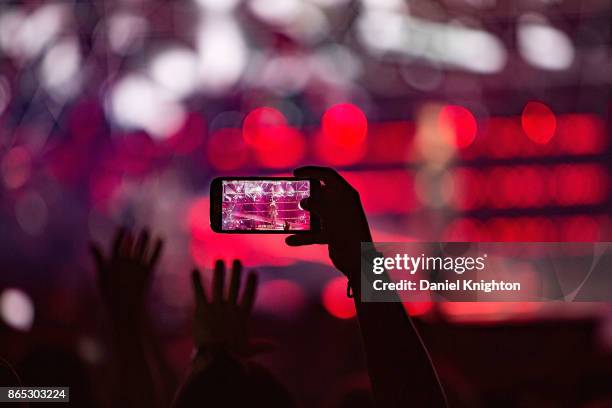 Fan uses a cell phone to take a photo of Pitbull performing on stage at Valley View Casino Center on October 22, 2017 in San Diego, California.