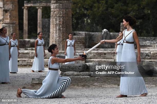 Actress Katerina Lechou acting the high priestess passes the Olympic flame at the Temple of Hera on October 23, 2017 during a dressed rehearsal of...