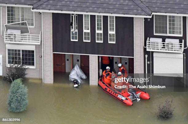 Fire fighters on a rescue boat visit an apartment building of inundated area after Typhoon Lan hit past Japan on October 23, 2017 in Kinokawa,...