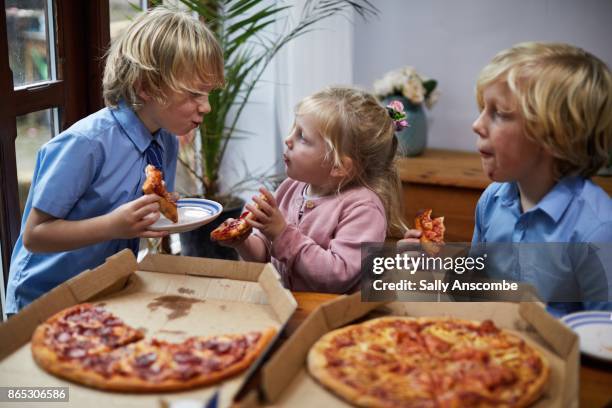 siblings eating pizza together - nur kinder stock-fotos und bilder