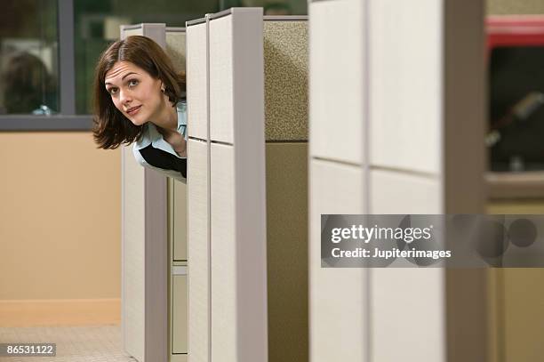 woman peeking out of cubicle - peeking cubicle stock pictures, royalty-free photos & images