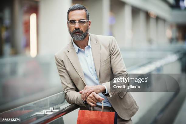 mid aged businessman at a shopping mall - grab handle stock pictures, royalty-free photos & images