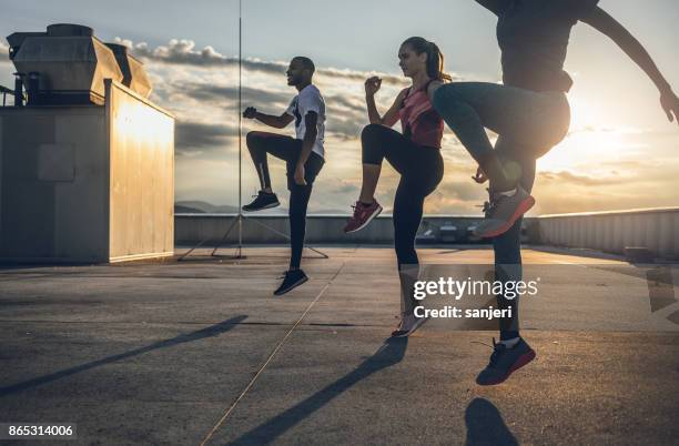three people exercising outdoors - warm up exercise stock pictures, royalty-free photos & images