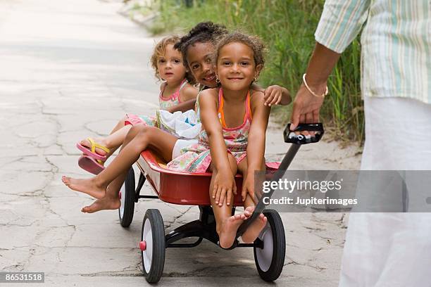 children in wagon - bollerwagen mann stock-fotos und bilder