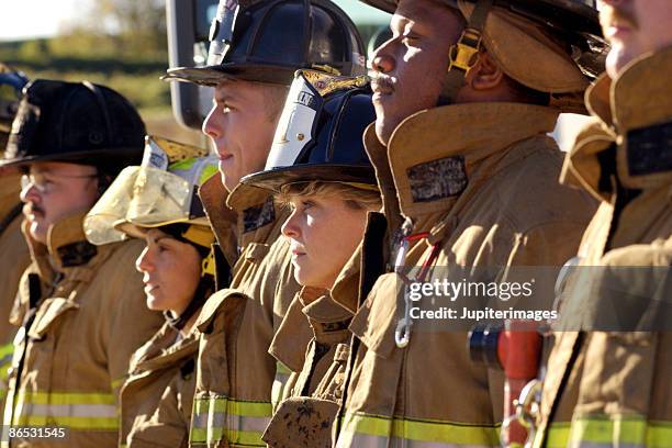 side view of firefighters - firefighters foto e immagini stock