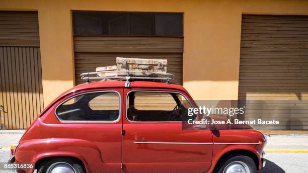 close-up of suitcases on car trunk, ancient car loaded with ancient suitcases of leather. valencia, spain - gestapelt leder stock-fotos und bilder