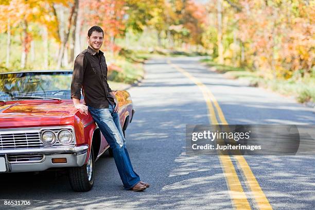 man leaning against convertible on road - full body car stock pictures, royalty-free photos & images