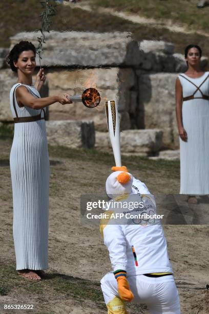 First Greek torchbearer for Pyeongchang 2018, cross-country skier Apostolos Angelis receives the Olympic flame from actress Katerina Lechou acting...
