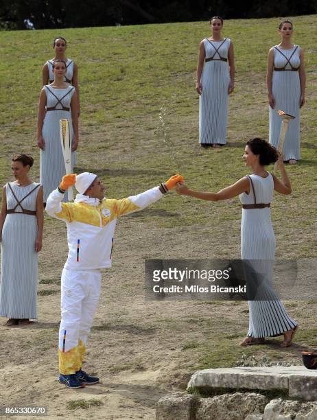 High priestess passes the Olympic flame to the first torch carrier Apostles Aggelis during a dressed rehearsal of the lighting ceremony of the...