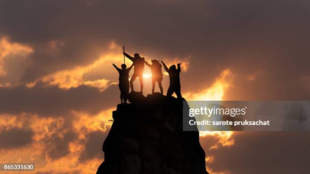 businessman and women group hike on the peak of silhouette rocks mountain at sunset, success, winner, leader concept - leaders summit stock pictures, royalty-free photos & images