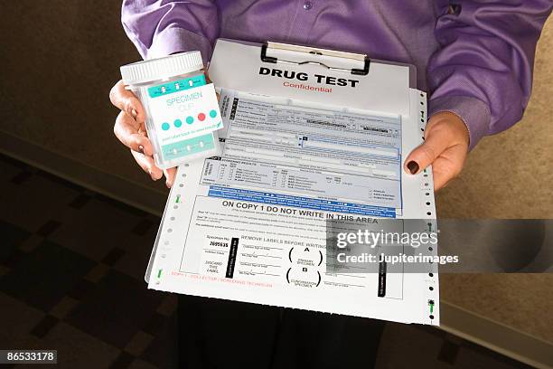 woman holding clipboard with drug test - drogentest stock-fotos und bilder