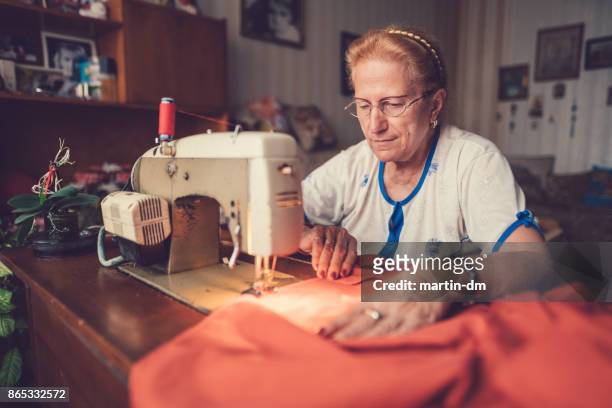 tailor woman working at the sewing machine - só uma mulher idosa imagens e fotografias de stock