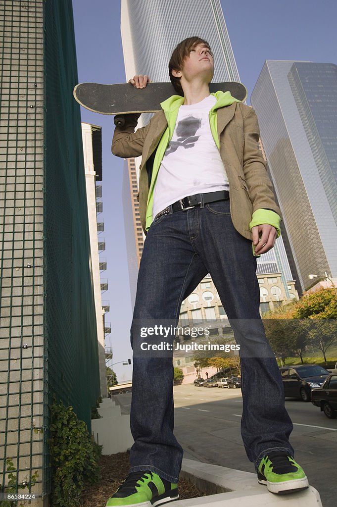 Teenage boy holding skateboard