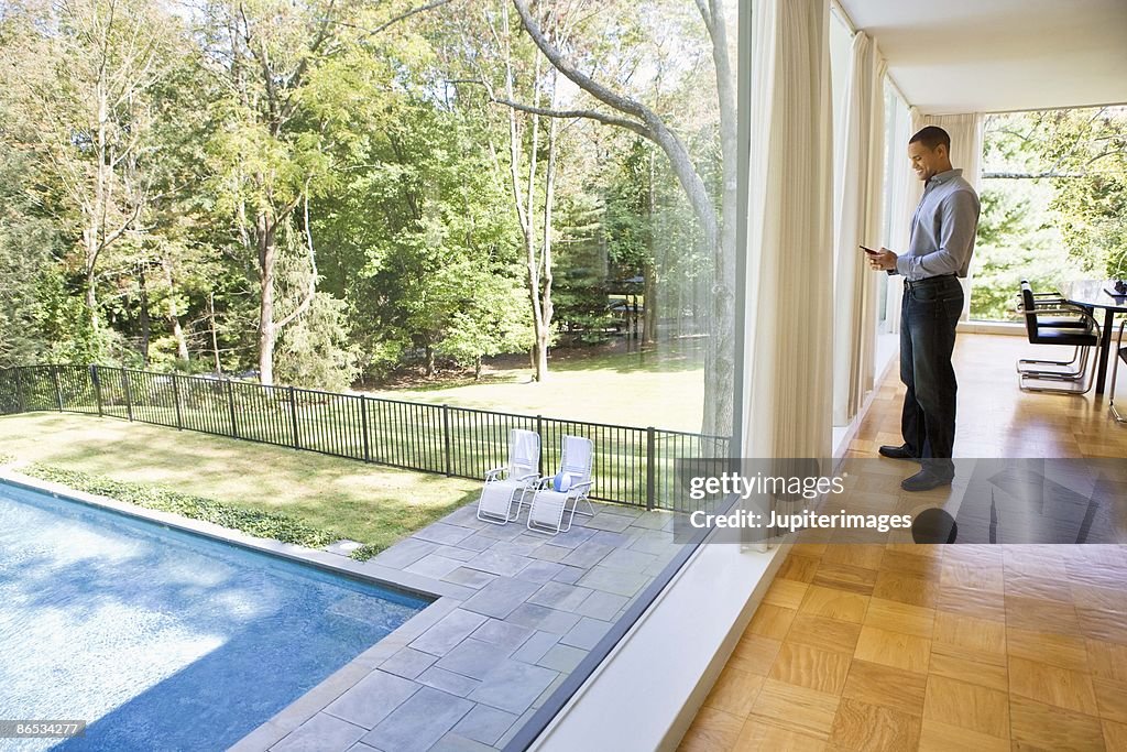 Man in glass house with cell phone