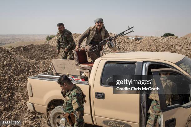 Peshmerga fighters prepare equipment as they fortify positions on the frontline outside the town of Altun Kubri on October 23, 2017 in Altun Kubri,...