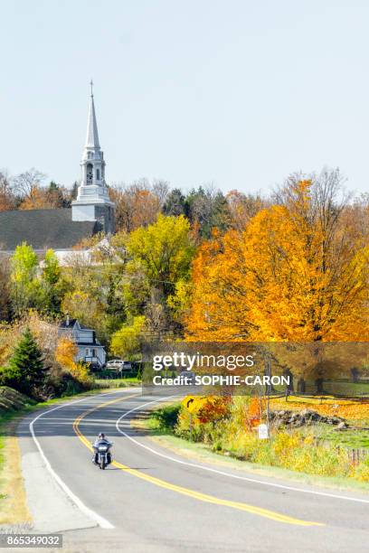 church in the eastern townships, autumn, motorcyclist. - eastern townships quebec stock pictures, royalty-free photos & images